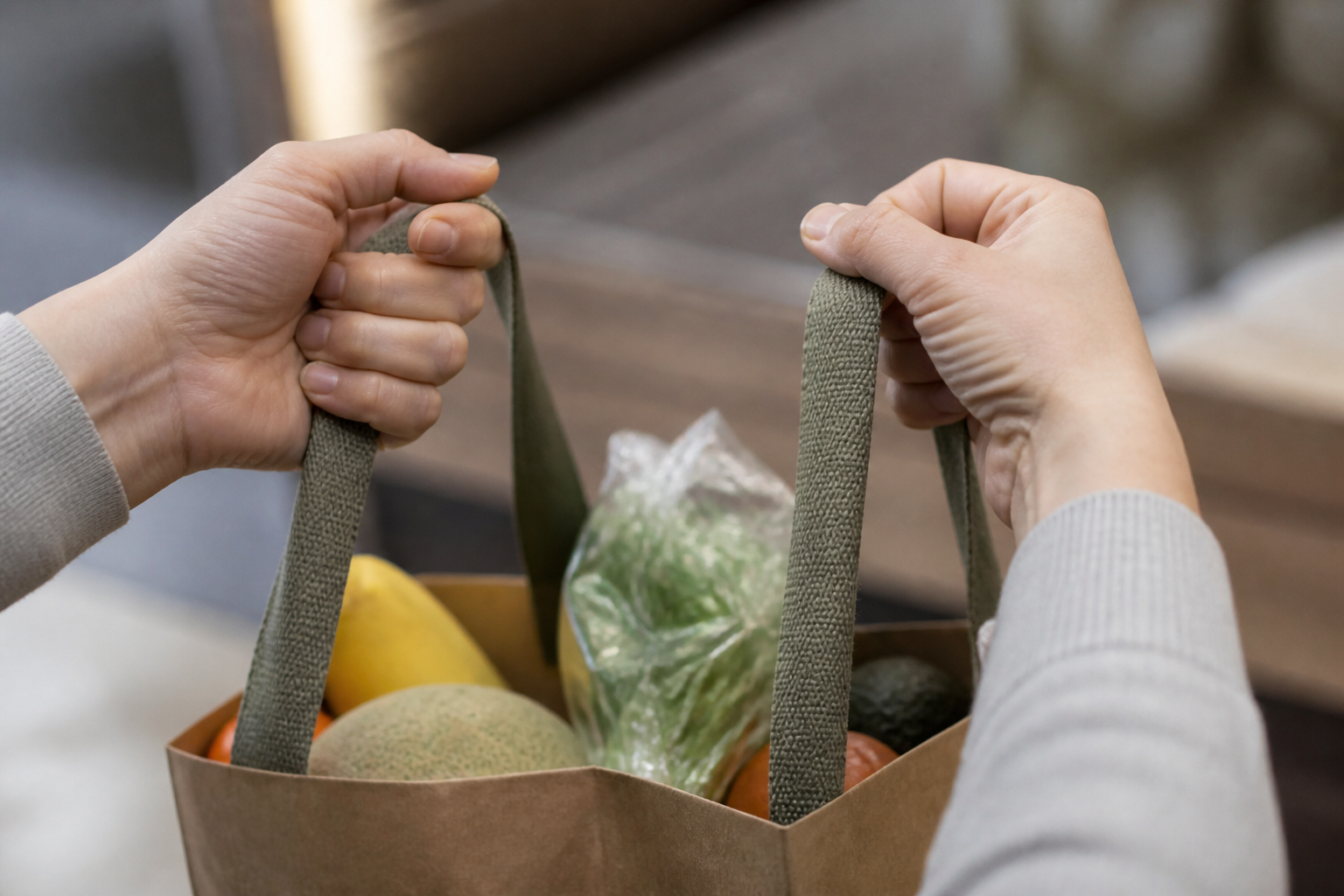 Close-up of hands gripping grocery bag handles, a common trigger for wrist and thumb strain